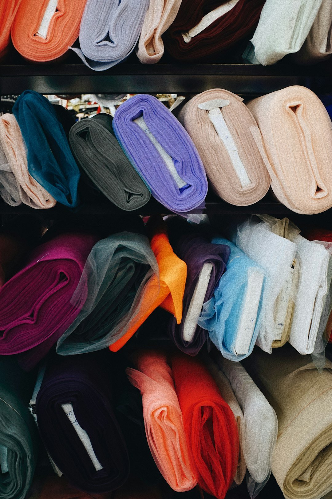 a-bunch-of-different-colors-of-cloth-on-a-shelf-vofq7q7kky8